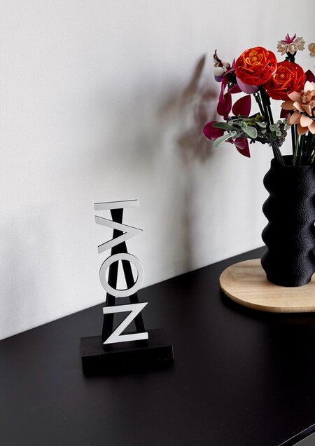 Display Stand op een nachtkastje naast een vaas met bloemen